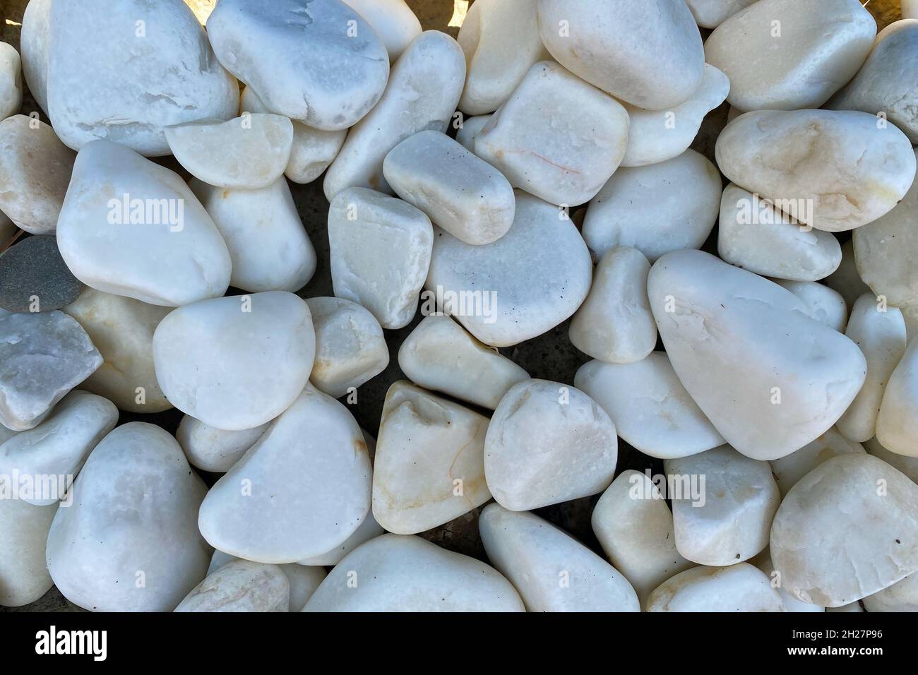 fondo liscio di ciottoli rotondi, primo piano ciottoli di mare, pietra grigio chiaro Foto Stock