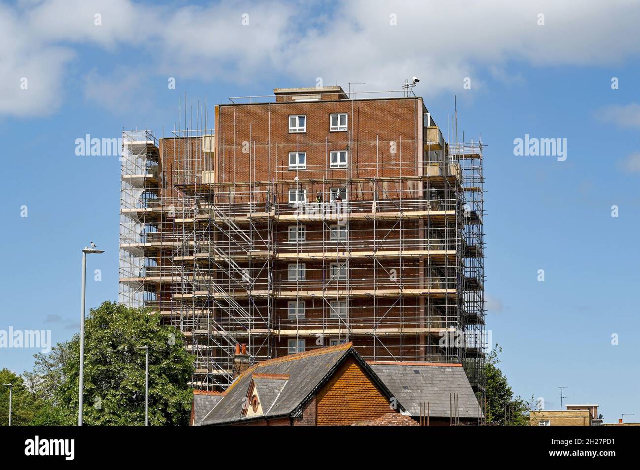 Poole, Dorset, Inghilterra - Giugno 2021: L'esterno di un blocco di appartamenti vicino al centro della città coperto di ponteggi per lavori di miglioramento della costruzione Foto Stock