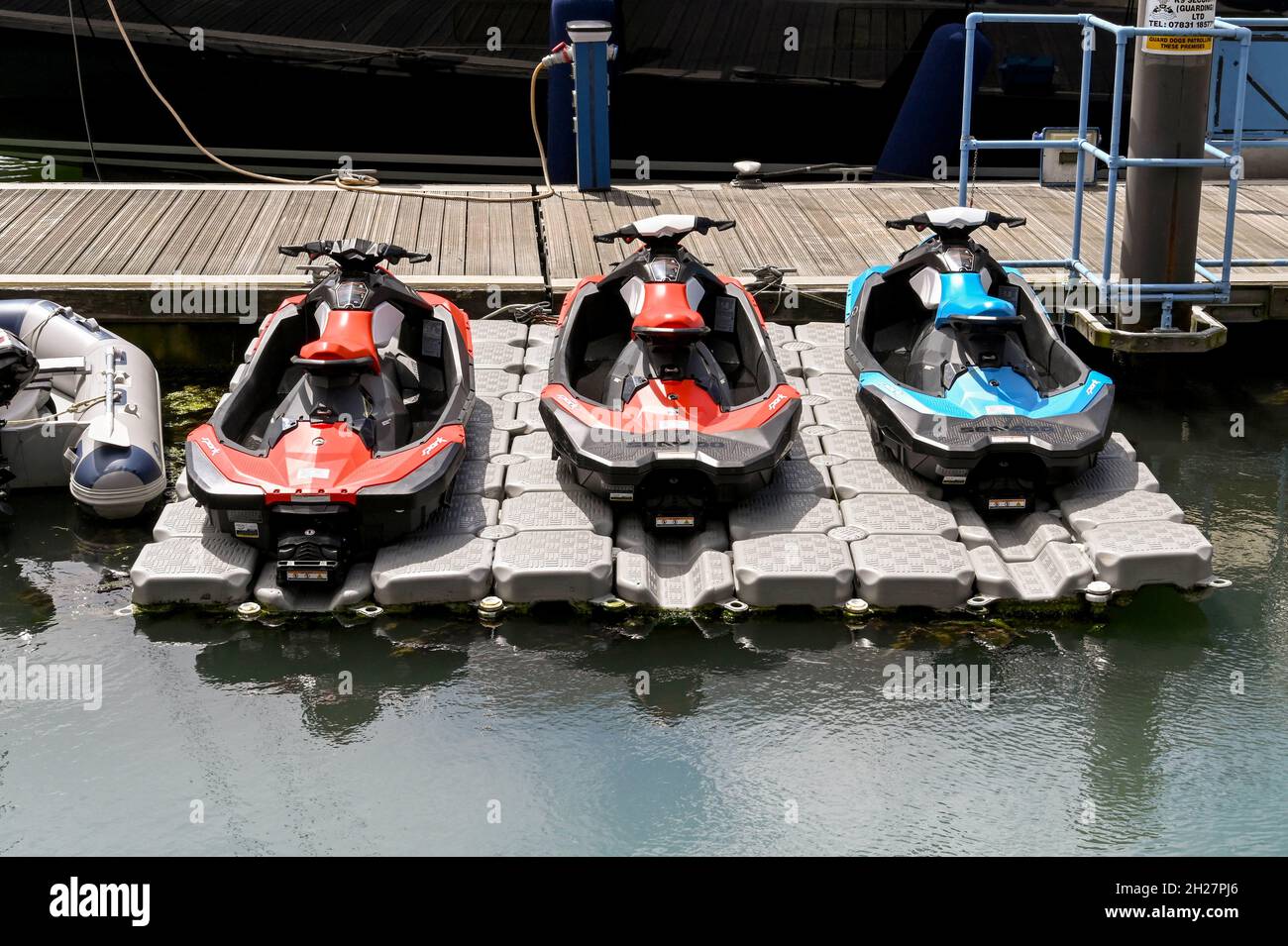 Poole, Dorset, Inghilterra - Giugno 2021: Moto d'acqua immagazzinato in rastrelliere galleggianti accanto al molo nel porto di Poole Foto Stock