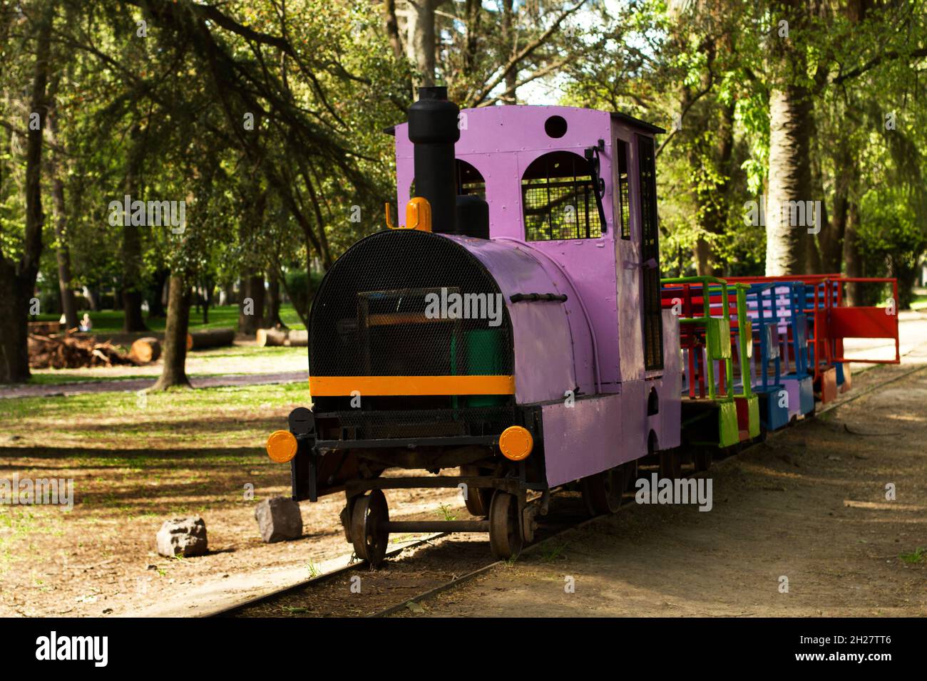 Un treno colorato per trasportare i bambini sulle rotaie in un parco Foto Stock