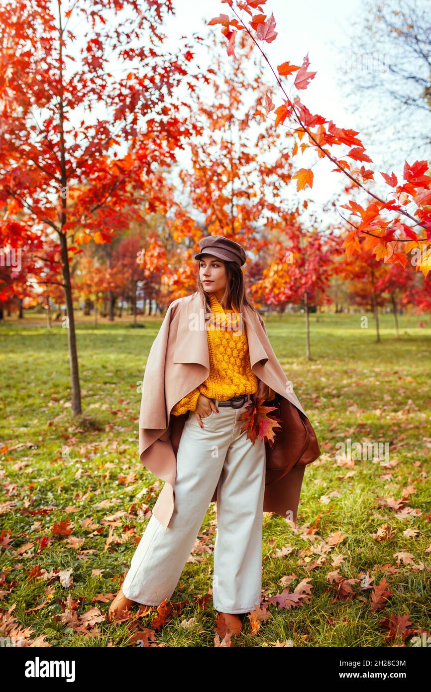 Ritratto a corpo pieno di bella donna indossando abiti caldi ed eleganti  nel parco autunnale tra gli alberi rossi. Moda autunno femminile. Accessori  moderni Foto stock - Alamy