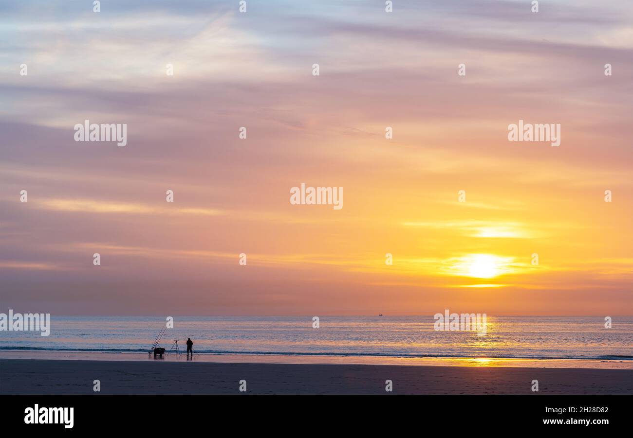 Silhouette di pescatori belgi al tramonto sulla spiaggia del Mare del Nord con spazio copia, Ostenda (Ostenda), Belgio. Foto Stock