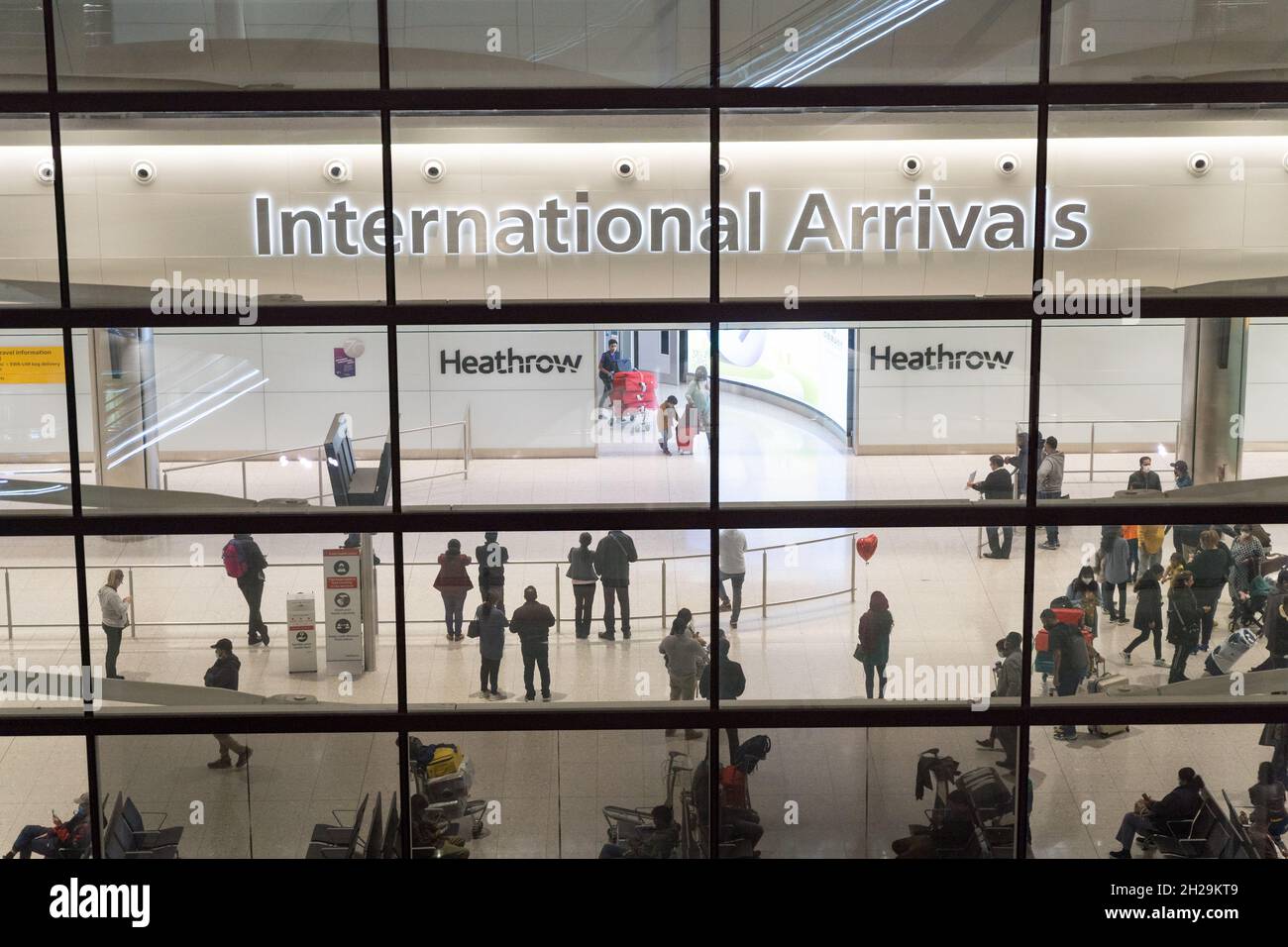 I passeggeri aerei arrivano nella sala degli arrivi dell'aeroporto internazionale di Heathrow, Londra Inghilterra Foto Stock