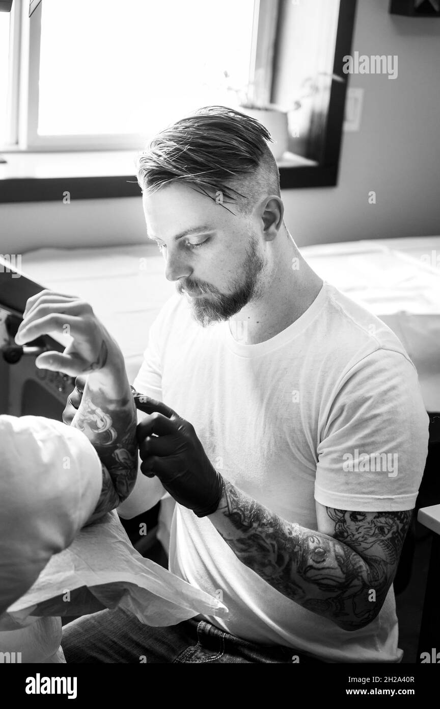 Un artista di tatuaggio prepara un cliente per un tatuaggio grande sul suo  braccio Foto stock - Alamy