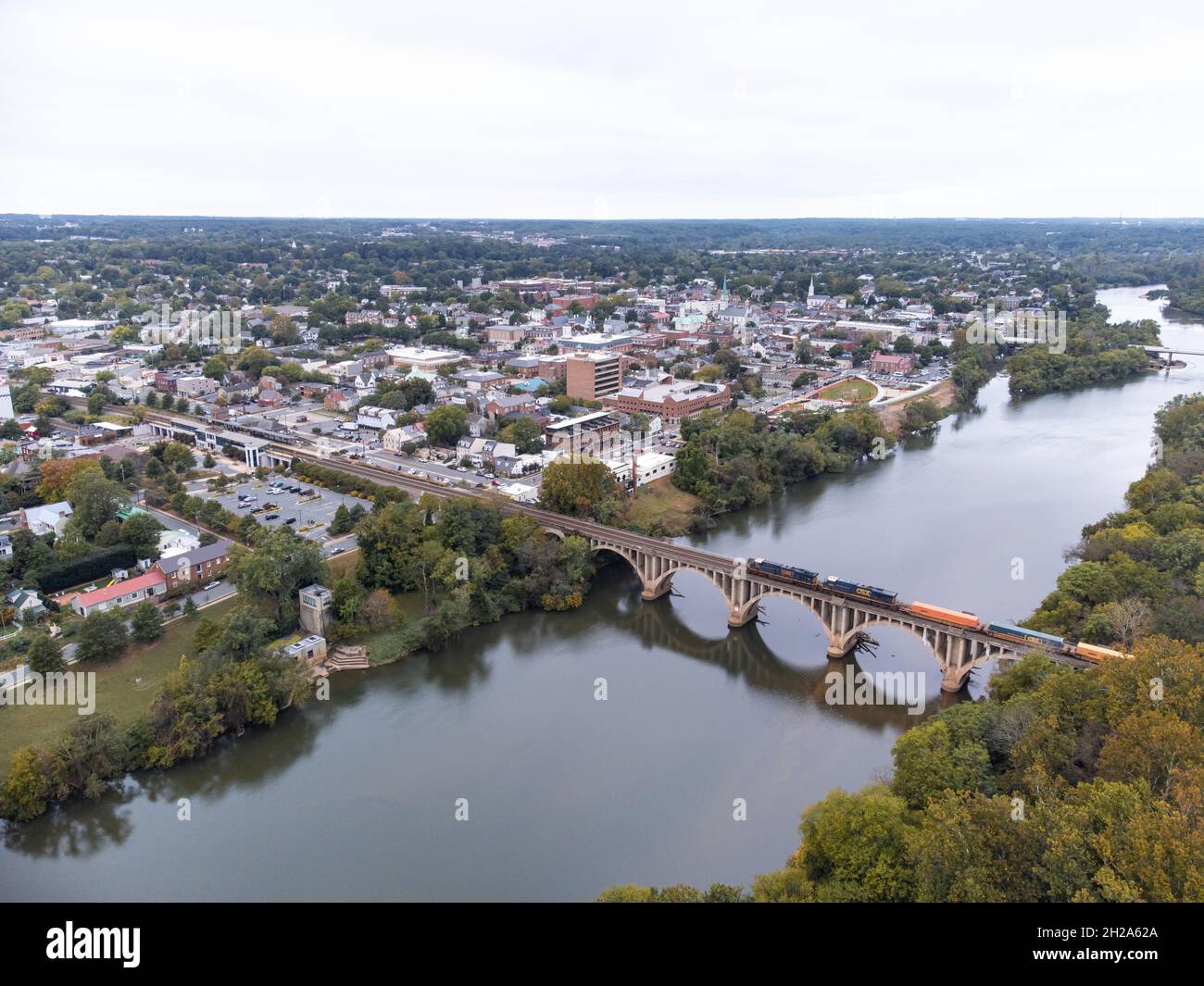 FREDERICKSBURG, STATI UNITI - 11 ottobre 2021: Una foto aerea del centro di Fredericksburg Virginia con un treno che passa sopra il Rappahannock via la F Foto Stock