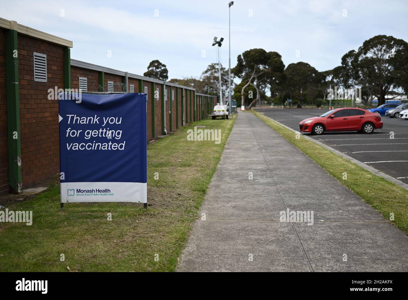 Un cartello, accanto a un sentiero e un parcheggio presso il centro di vaccinazione di Sandown Park, che ringrazia la gente per aver ottenuto la vaccinazione COVID-19 Foto Stock