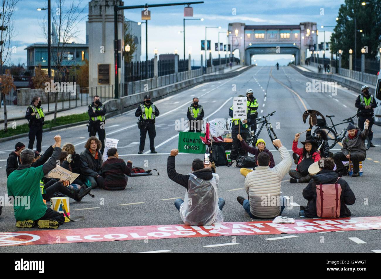 Vancouver, British Columbia, Canada. 20 Ott 2021. La polizia di Vancouver monitora gli attivisti climatici all'incrocio tra Burrard Street e Pacific Street, ottobre 20. Circa 25 manifestanti non violenti con il gruppo d'azione per il clima Extinction Rebellion Vancouver hanno effettivamente chiuso tutte le ore di punta del ponte di Burrard Street dalle 17:30 alle 19:00 circa due persone sono state arrestate per accuse di malizia, intimidazione e ostruzione di una strada. Gli arresti e il blocco fanno parte della serie di proteste pianificate dall'organizzazione in tutto il Lower Mainland questo mese per richiedere un Foto Stock