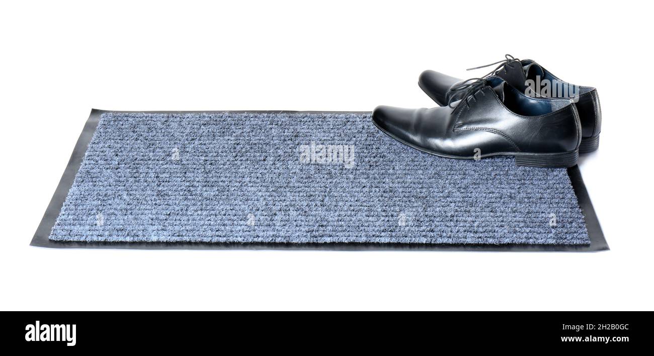 Scarpe classiche nere su tappetino grigio su sfondo bianco Foto Stock