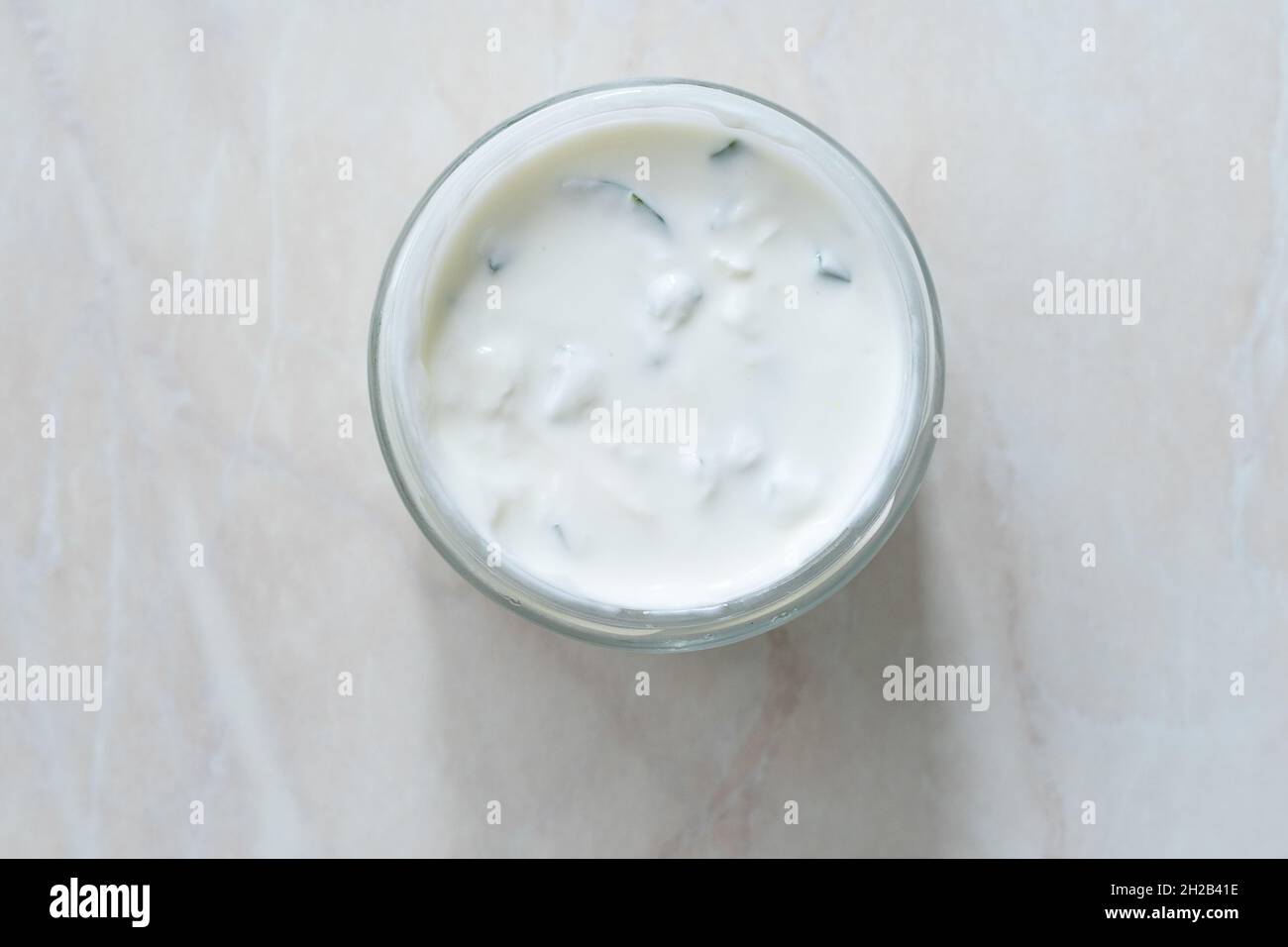 Take away Tzatziki - salsa tradizionale greca di yogurt in ciotola di vetro. Pronto a mangiare. Foto Stock