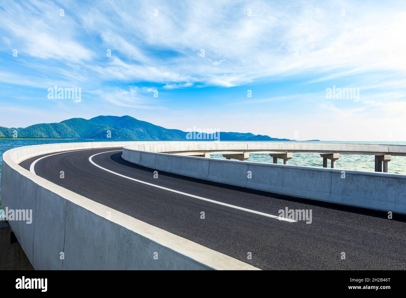 Nuova strada asfaltata e montagna con paesaggio naturale fluviale in estate. Foto Stock