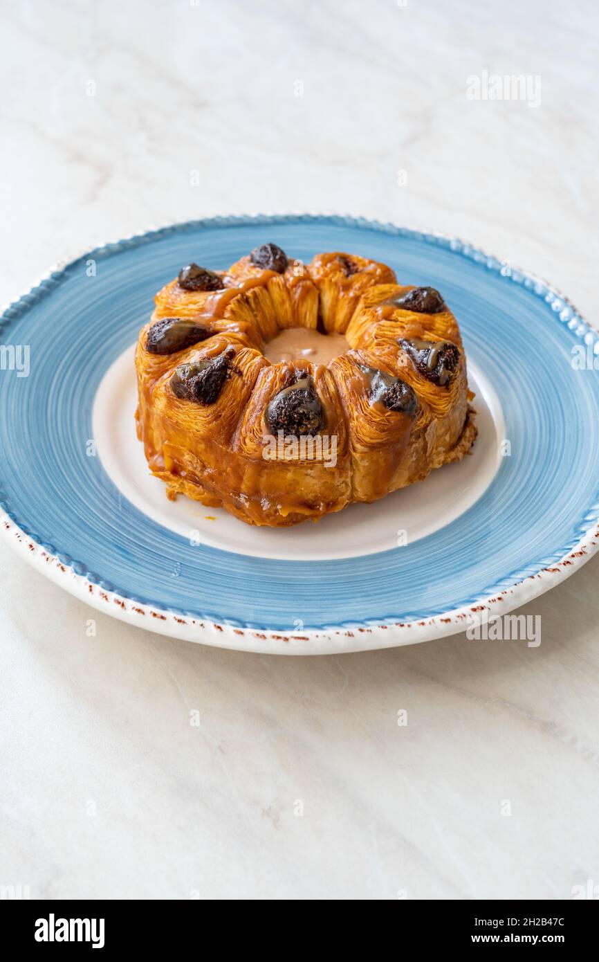Croissant rotondo con praline pralina al cioccolato in piatto. Pronto a mangiare. Foto Stock