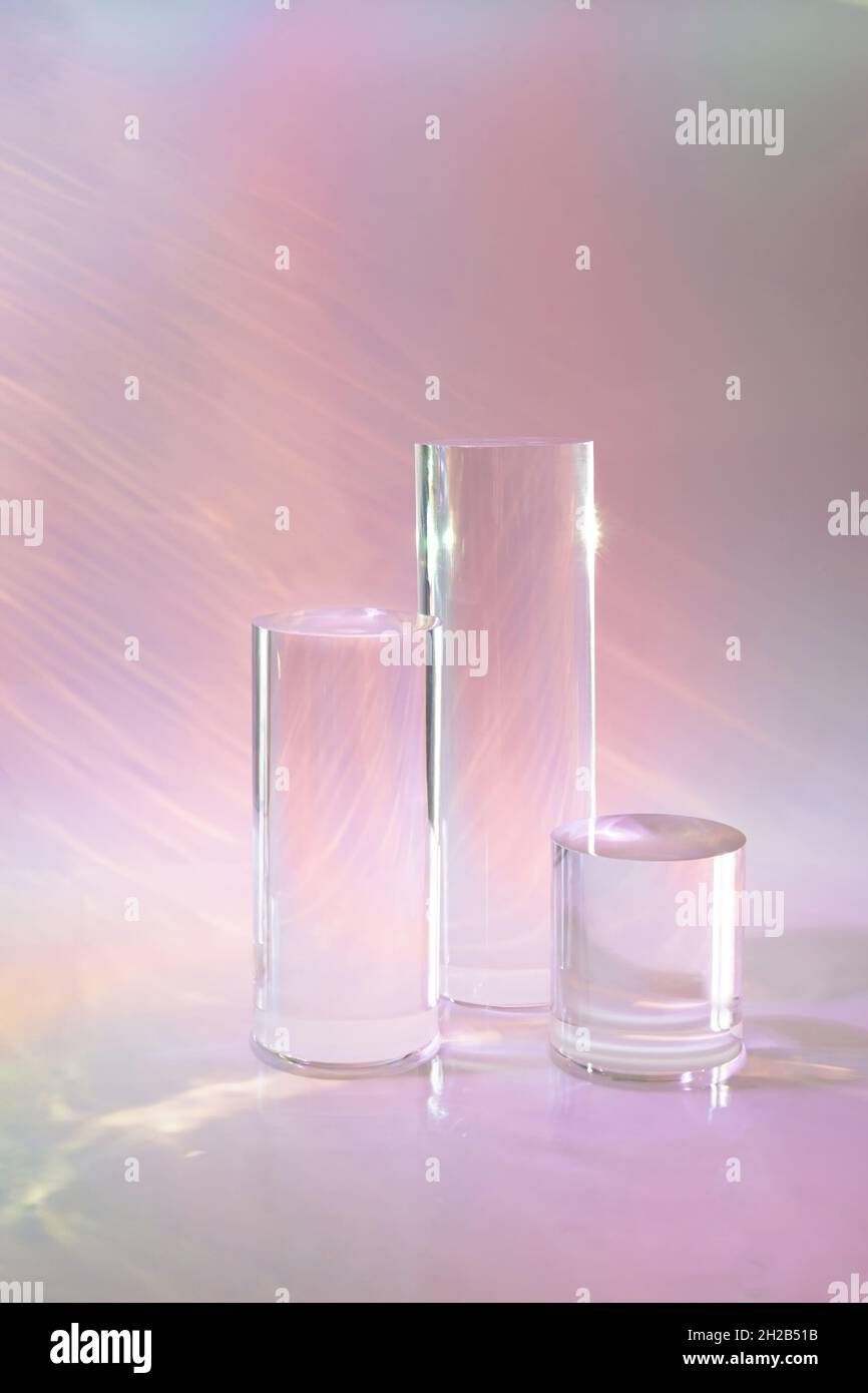 tre podi in vetro chiaro su sfondo rosa pastello Foto Stock