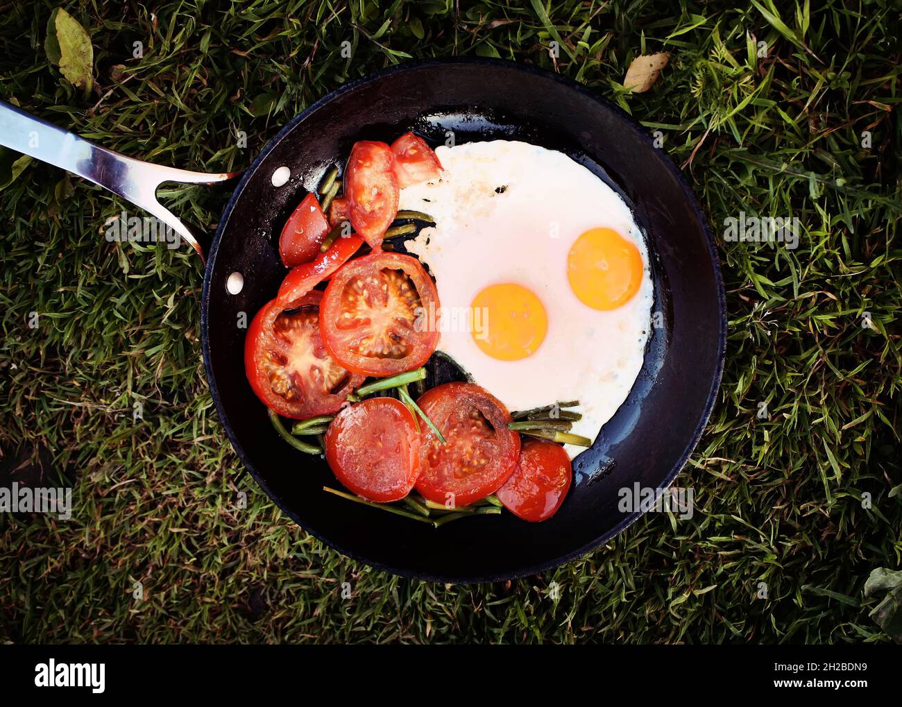 Uova fritte in stile country con pomodori rossi freschi Foto Stock