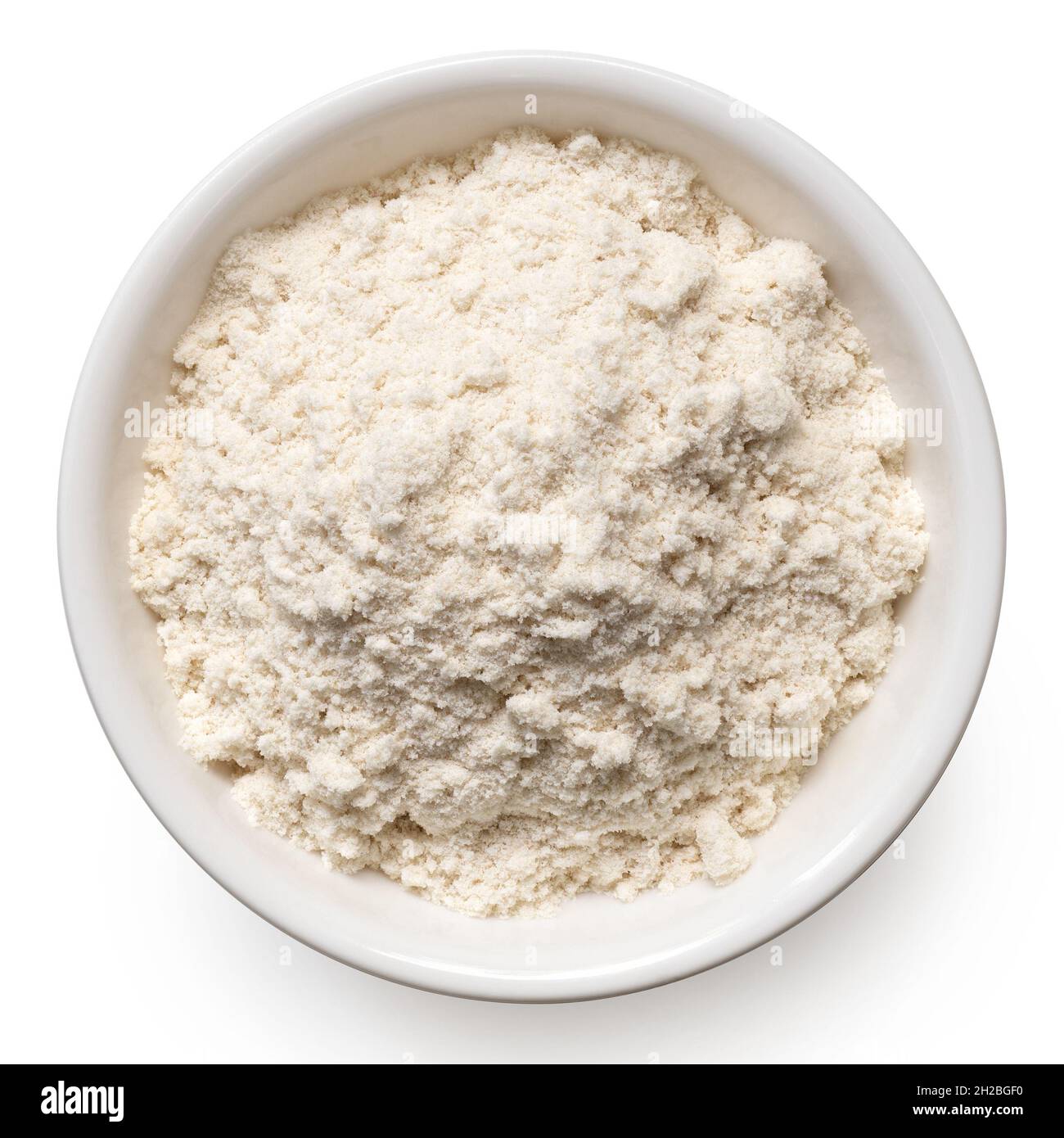 Far rosolare la farina di riso in un recipiente di ceramica bianca isolato su bianco. Vista dall'alto. Foto Stock