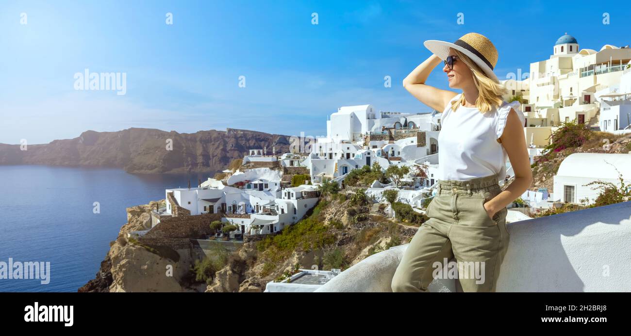 Donna che gode di vista sul mare a Oia sull'isola di Santorini, in Grecia. Spazio copia Foto Stock