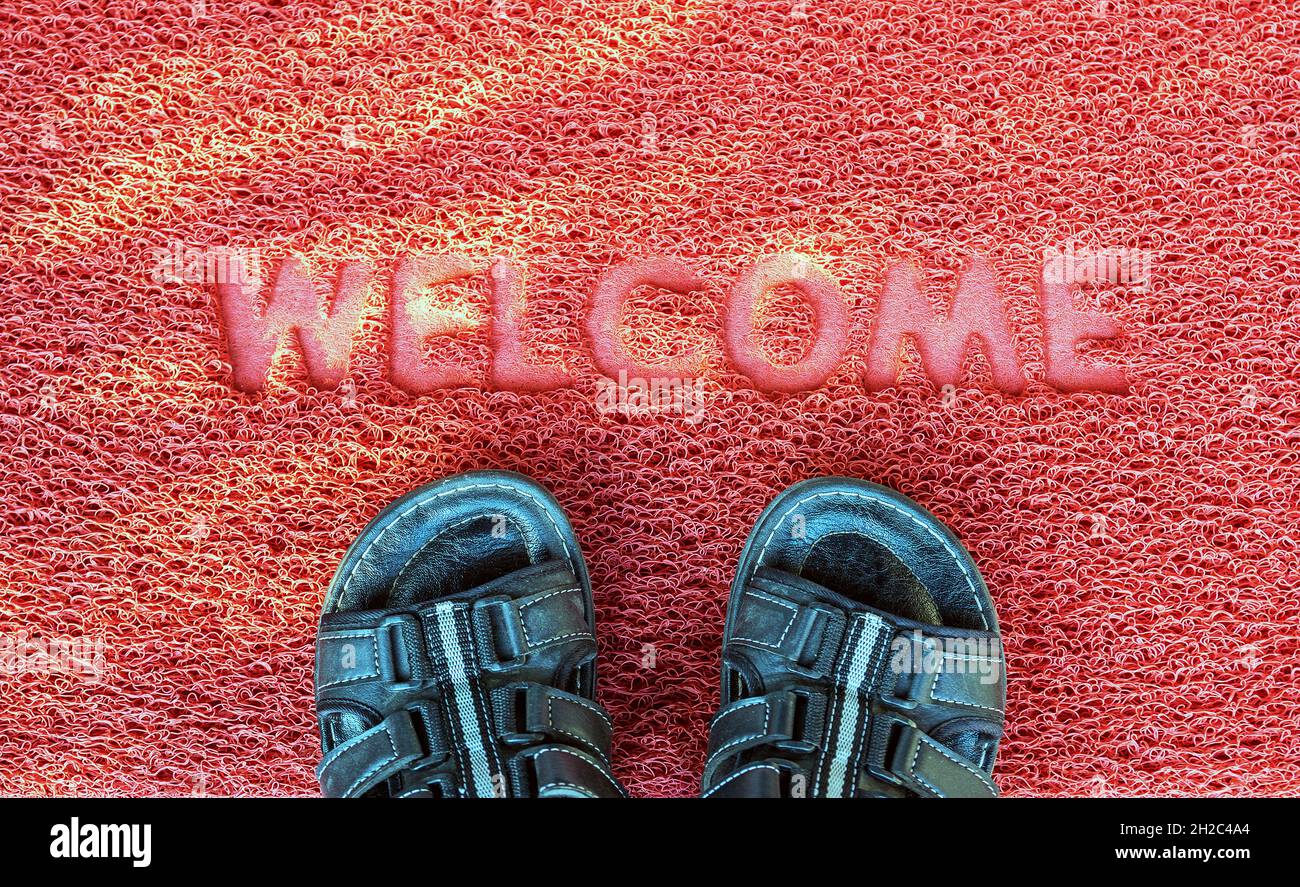 Benvenuti porta capet con piedi ware su di esso. Foto Stock