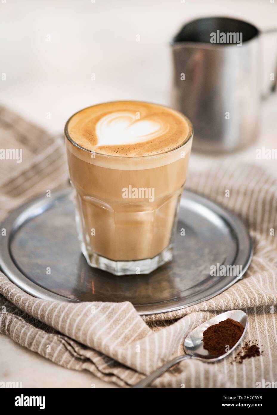 Caffè bianco piatto con latte in schiuma a forma di cuore sul vassoio Foto Stock