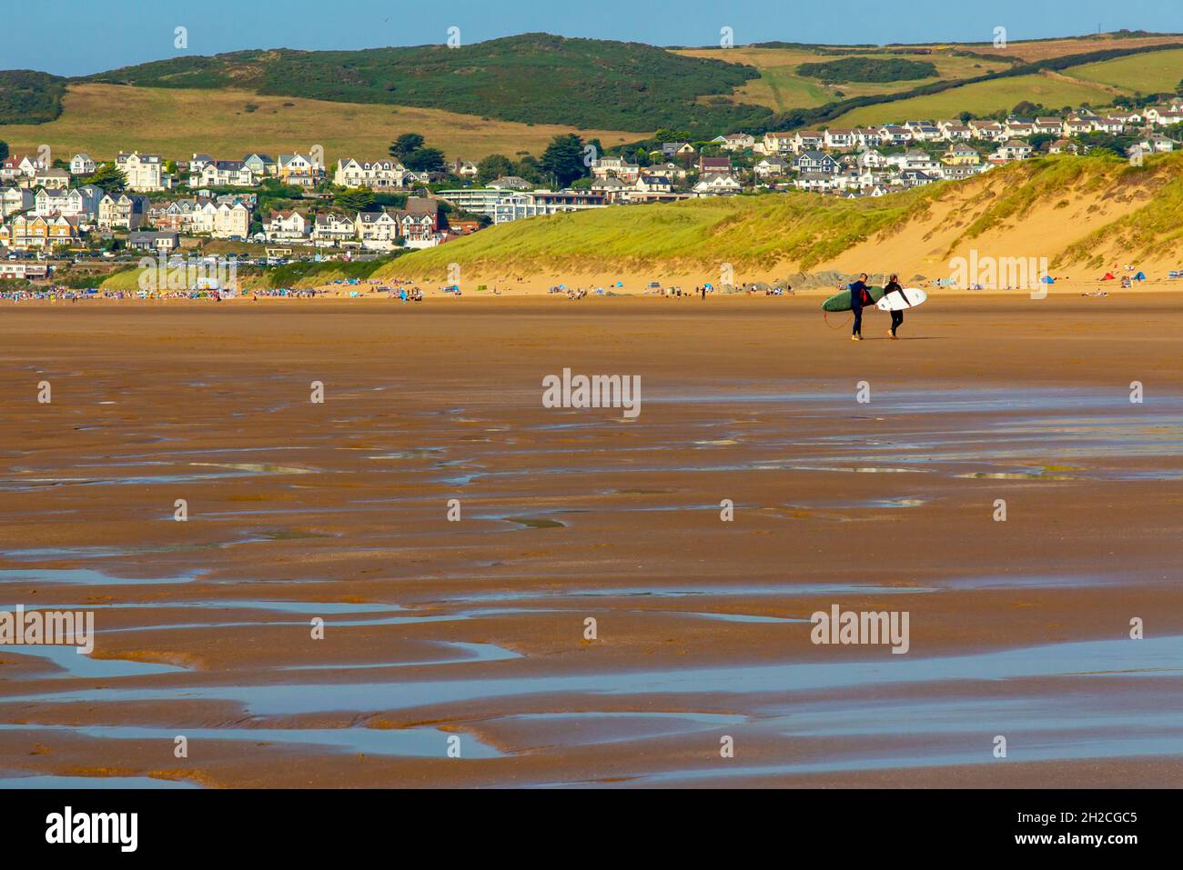 Surfers sulla spiaggia di sabbia a Woolacombe sulla costa nord del Devon Inghilterra Regno Unito vicino al South West Coast Path. Foto Stock