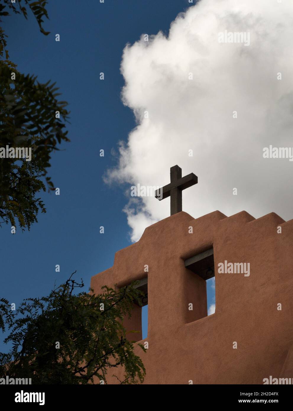Una croce sulla cima di una storica chiesa di adobe a Santa Fe, New Mexico. Foto Stock