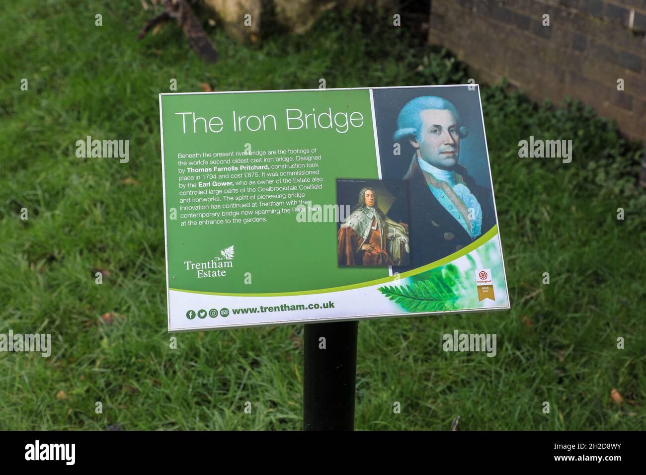 Una bacheca informativa che spiega le origini del secondo ponte in ghisa più antico dei Trentham Gardens, Stoke-on-Trent, Staffordshire, Inghilterra, Regno Unito Foto Stock