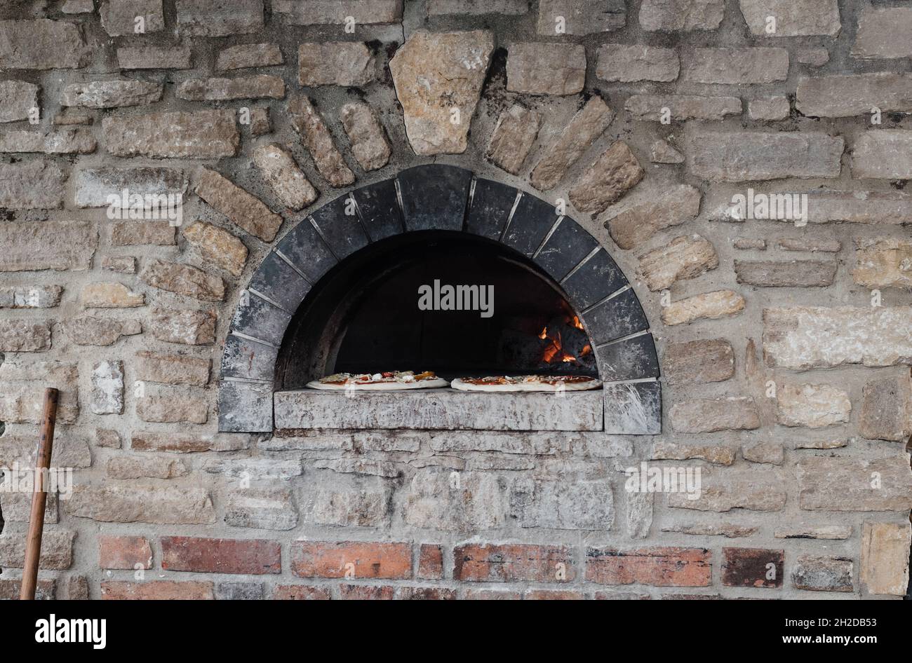 forno a legna per pizza all'aperto con due pizze pronte per cucinare Foto Stock