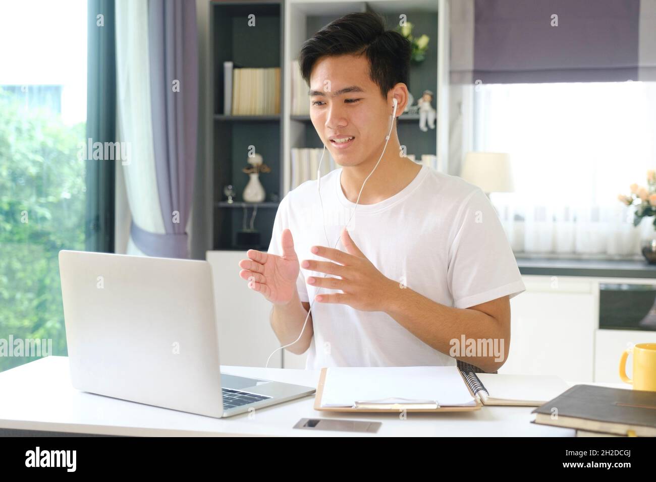 Giovane uomo che lavora e studia online a casa. Lavoro online e apprendimento online. Foto Stock