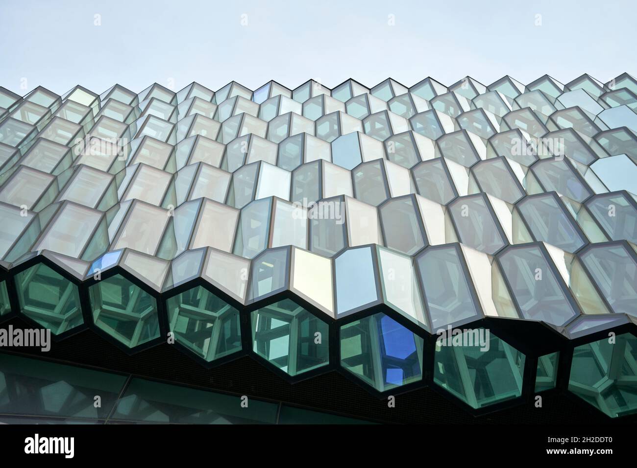 Dal basso di un edificio futuristico con pareti in vetro creative con elementi a forma di nido d'ape contro il cielo blu nella giornata di sole in Islanda Foto Stock