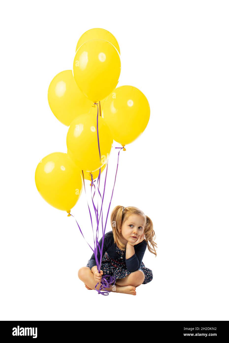 ritratto su bianco di bambina con palloncini che mostrano l'espressione annoiato Foto Stock