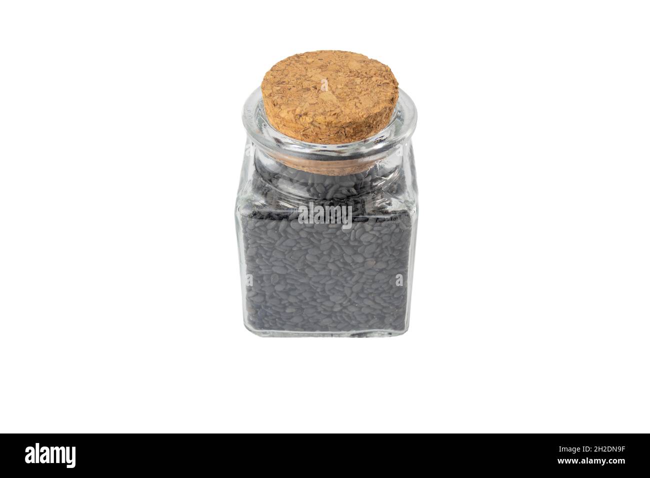 Semi di Sesamo nero in un vaso di vetro isolato su sfondo bianco. Spezie e ingredienti alimentari. Foto Stock