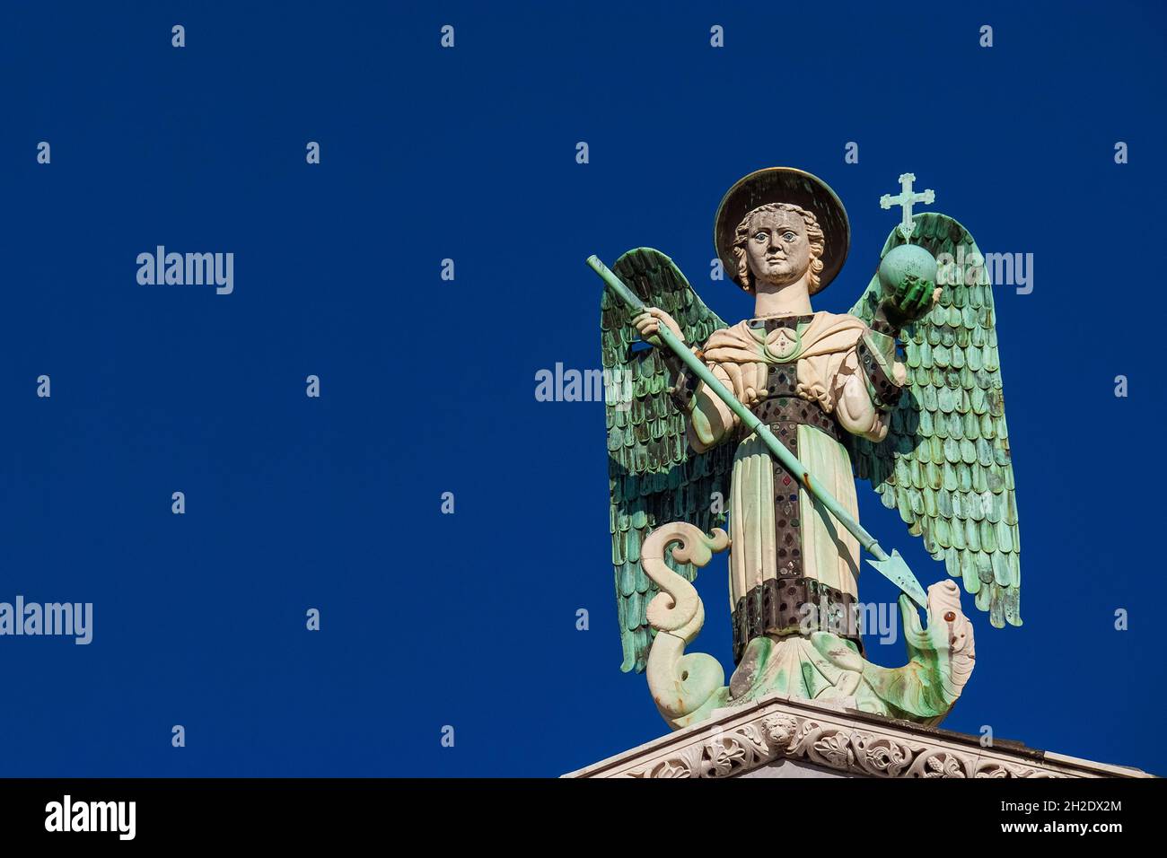 San Michele Arcangelo sconfigge il Drago, una statua medievale del XIII secolo in cima alla Chiesa di San Michele a Lucca (con cielo blu e spazio per le copie) Foto Stock