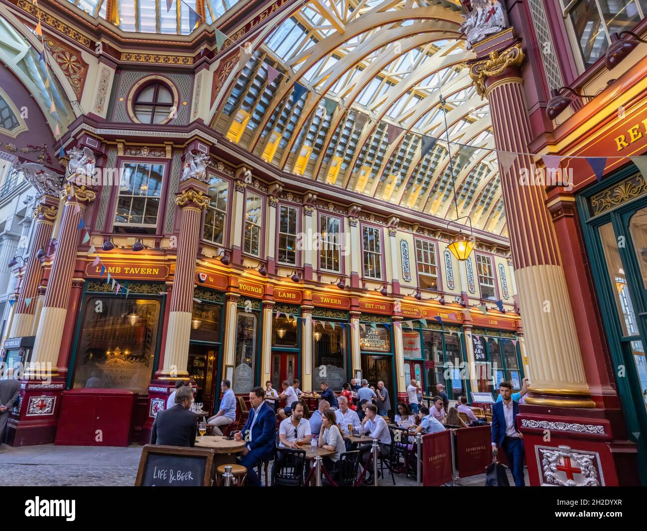 I clienti bevono e socializzano ai tavoli all'esterno della Taverna degli agnelli nello storico mercato di Leadenhall a Gracechurch Street, nella città di Londra, EC3 Foto Stock