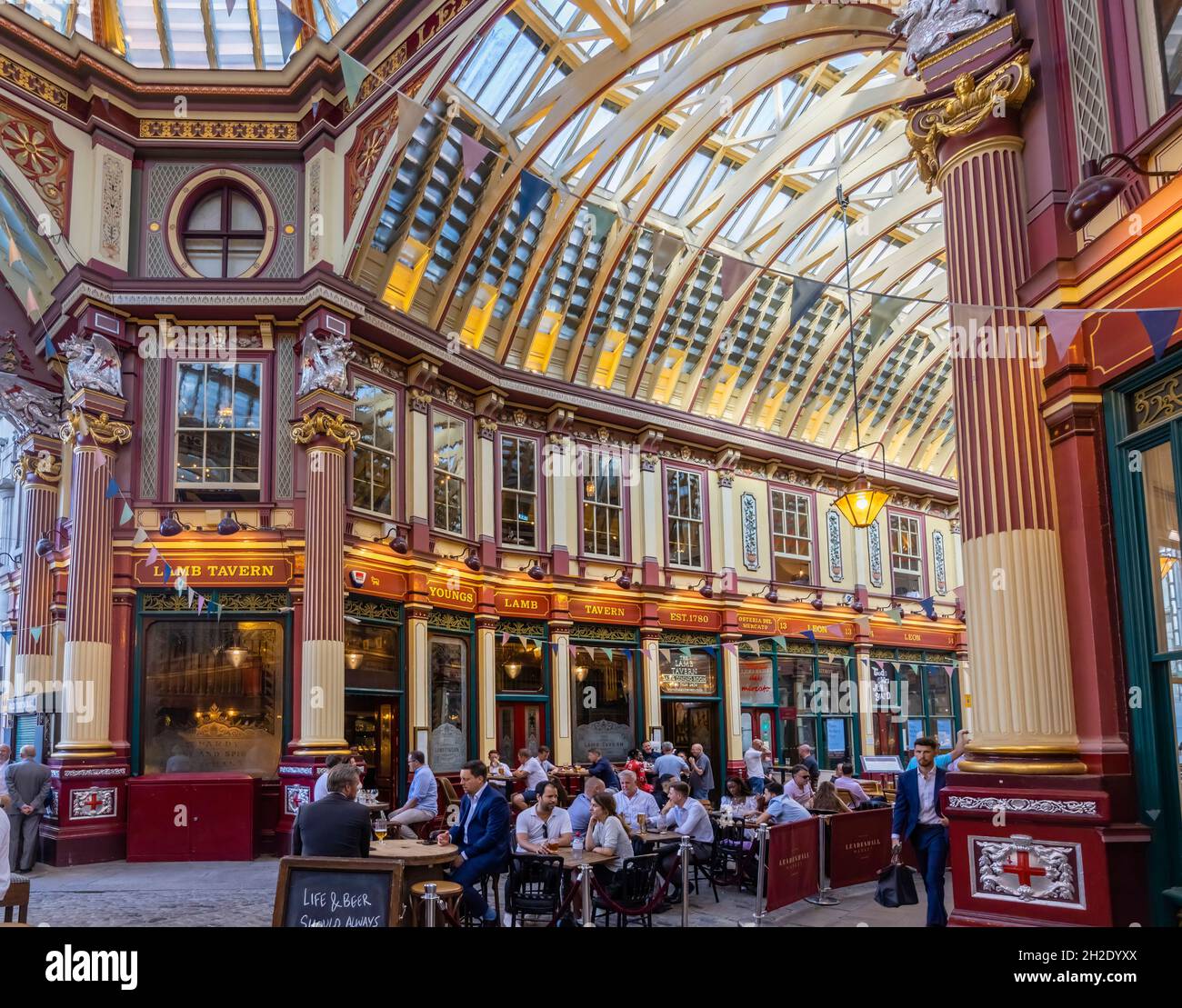 I clienti bevono e socializzano ai tavoli all'esterno della Taverna degli agnelli nello storico mercato di Leadenhall a Gracechurch Street, nella città di Londra, EC3 Foto Stock