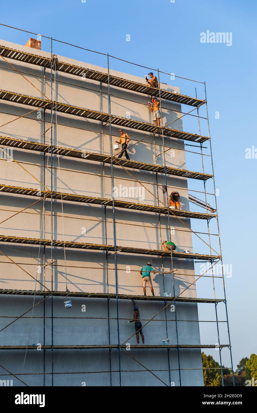 UZHGOROD, UCRAINA - 16 settembre 2021: Operai di costruzione che mettono l'intonaco decorativo sull'esterno della casa. Isolamento termico della facciata e lavori di pittura Foto Stock