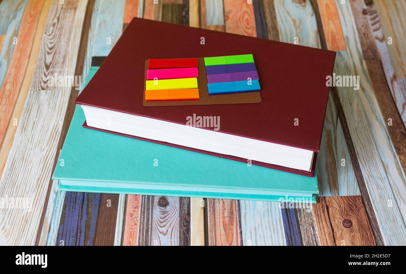 Quaderni colorati e adesivi colorati su sfondo a strisce alla moda Foto Stock