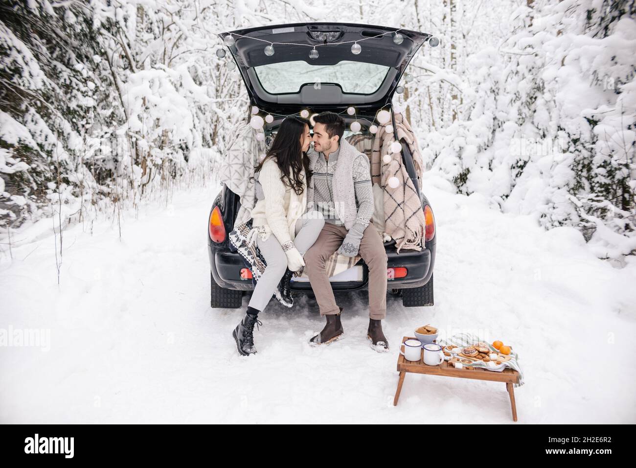 Coppia carina che ha Winter Forest picnic. Picnic natura. Data storia dell'amore in macchina. Foto Stock