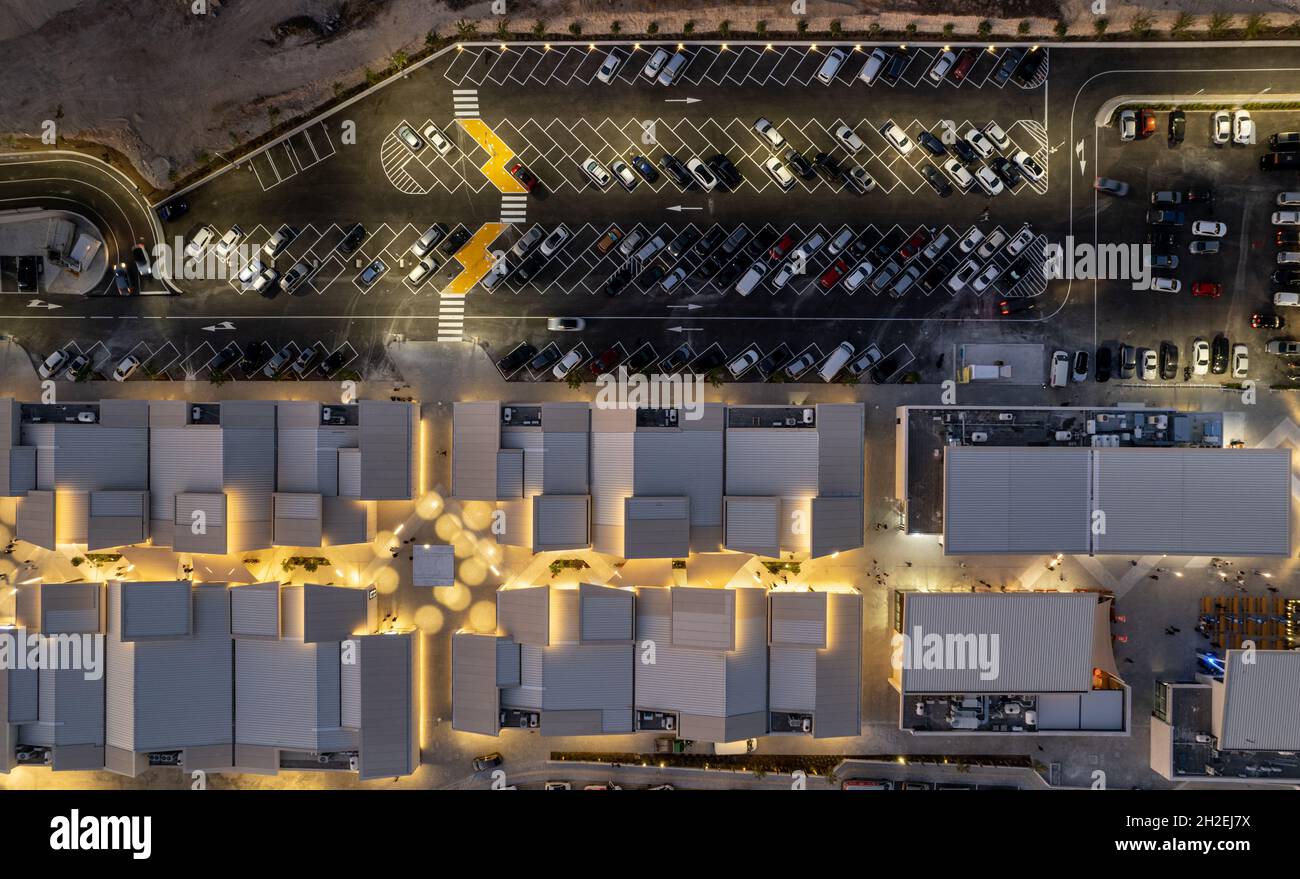 Vista aerea del drone dei parcheggi con auto di notte. Parcheggio affollato per il centro commerciale. Foto Stock