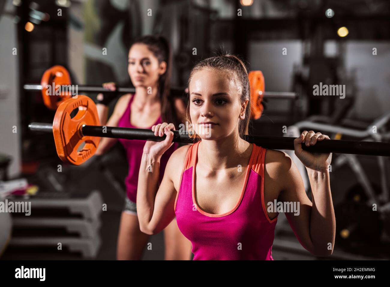 Primo piano delle donne che fanno esercizi nel centro benessere. In background attrezzature fitness. Foto Stock