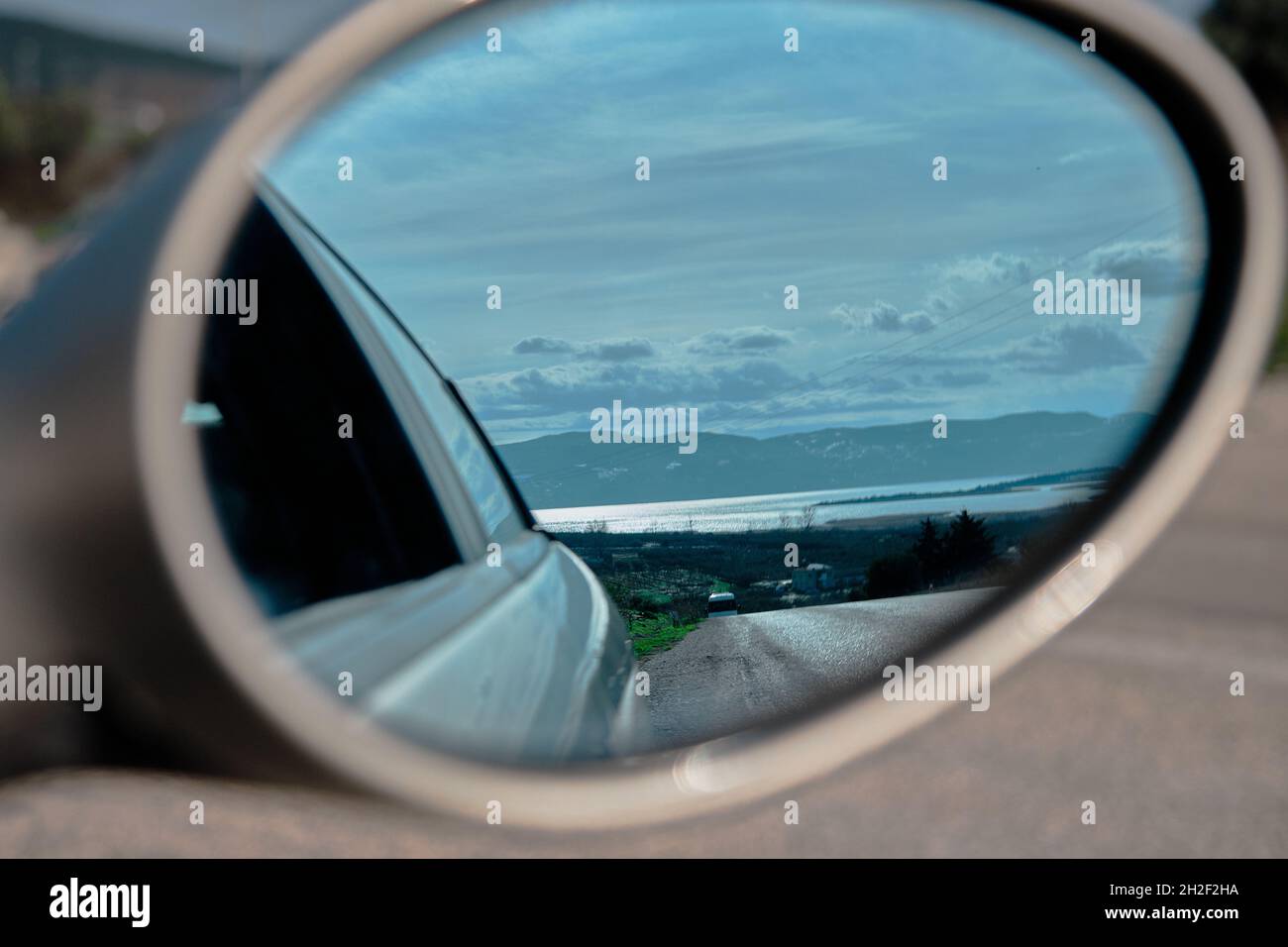 Osservazione del Lago Uluabat (apollyon) da un'auto specchio posteriore in cima alla piccola collina con strade ghiaiose. Foto Stock