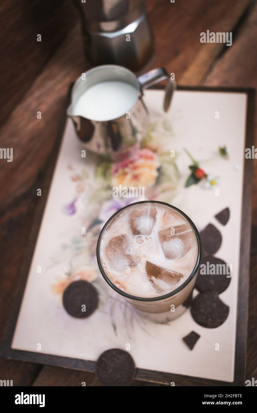 Vassoio caffè ghiacciato con latte e cioccolato su sfondo di legno Foto Stock