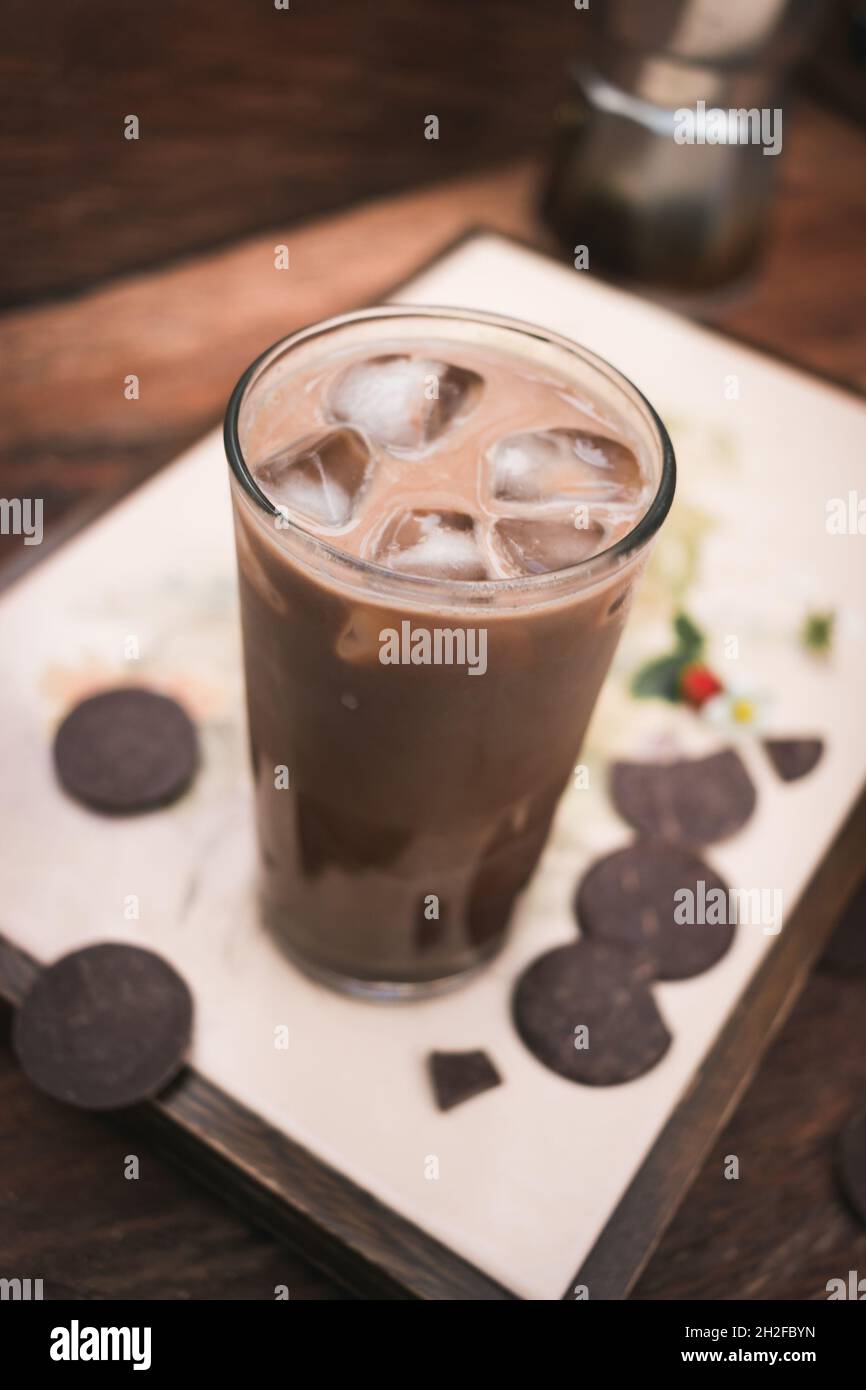 Vassoio caffè ghiacciato con latte e cioccolato su sfondo di legno Foto Stock