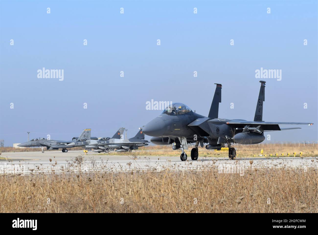 US F-15E Sciopero aquile dal 336th Fighter Squadron, 4th Fighter Wing, Seymour Johnson Air Force base, North Carolina, taxi accanto a rumeno F-16 Fighting Falcon aereo durante la seconda settimana di operazione Castle Forge a Balcea Air base, Romania, 20 ottobre 2021. L’obiettivo centrale di Castle Forge è quello di fornire un ambiente incentrato sulla partnership e affermare l’impegno degli Stati Uniti nei confronti degli alleati della NATO nella regione del Mar Nero (U.S.A. Air Force foto di Capt. Andrew Layton). Foto Stock