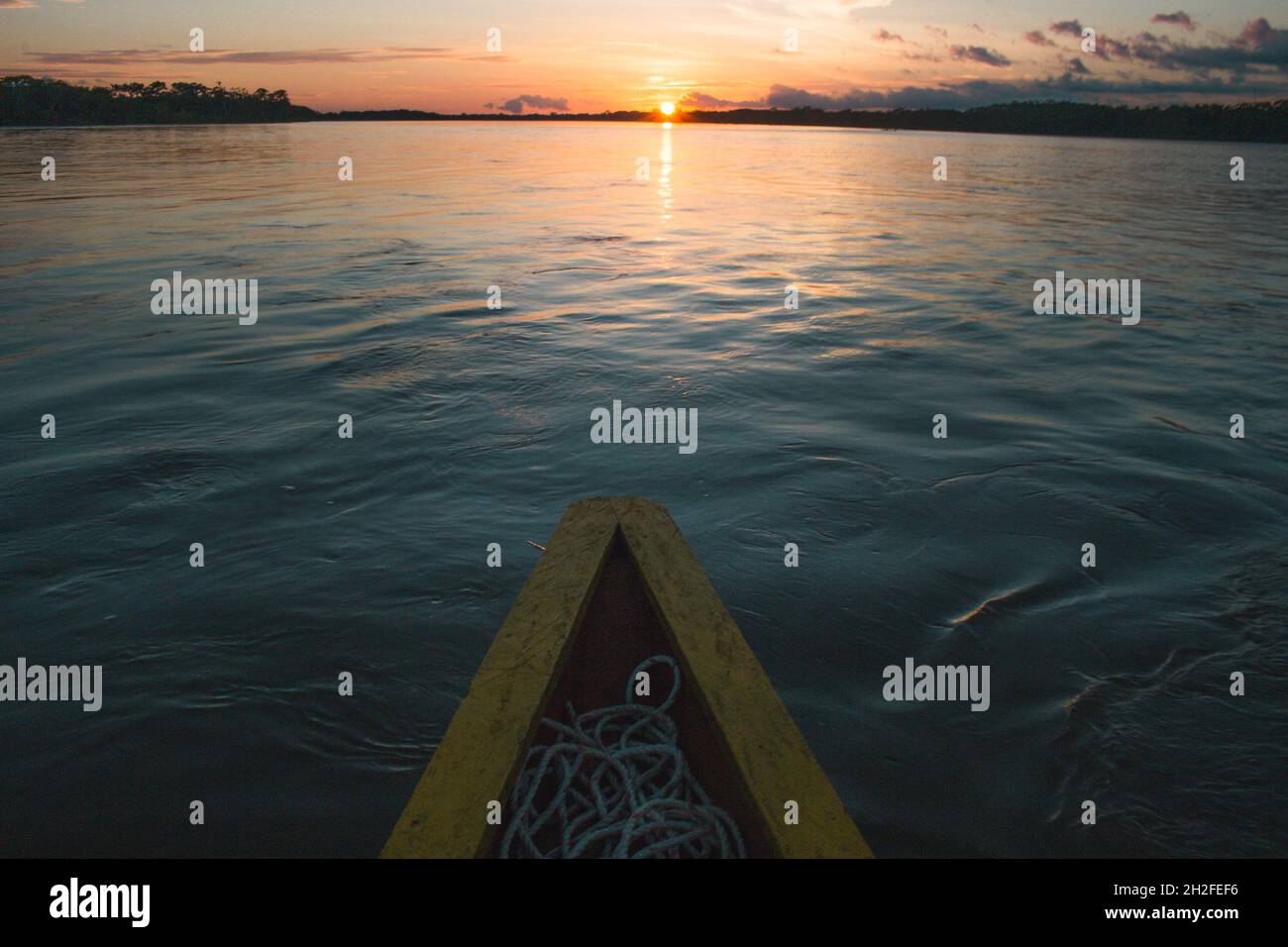 Tramonto rosso sangue sul fiume su una barca shabby Foto Stock