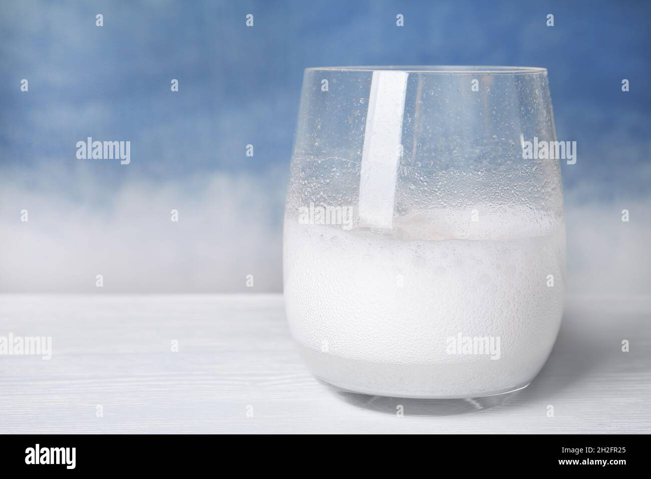 Reazione chimica dell'aceto e del bicarbonato in vetro sul tavolo. Spazio  per il testo Foto stock - Alamy