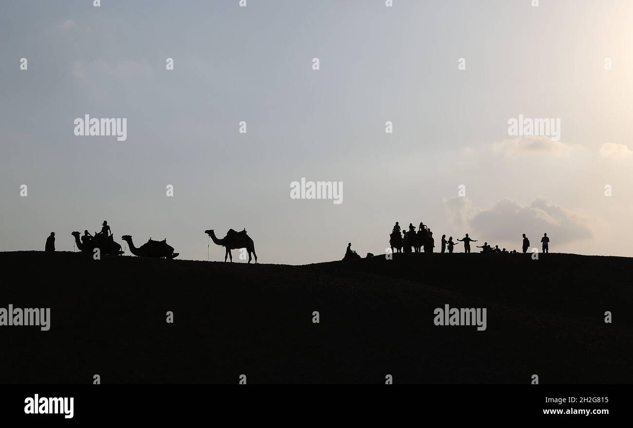 Cairo, Egitto. 21 ottobre 2021. I turisti cavalcano cammelli per visitare  il punto panoramico delle piramidi di Giza a Giza, Egitto, il 21 ottobre  2021. L'Egitto è entrato nella stagione turistica di