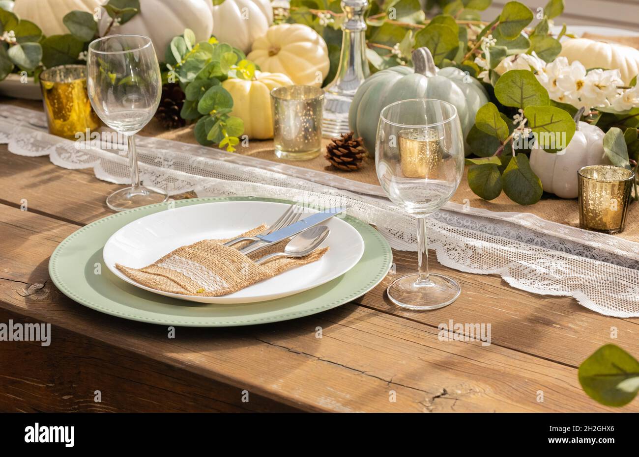 Decorazione autunnale e del giorno del Ringraziamento con mini zucche bianche. Riservato Thanksgiving o Halloween luogo impostazione in un casale tavolo set con mini Foto Stock