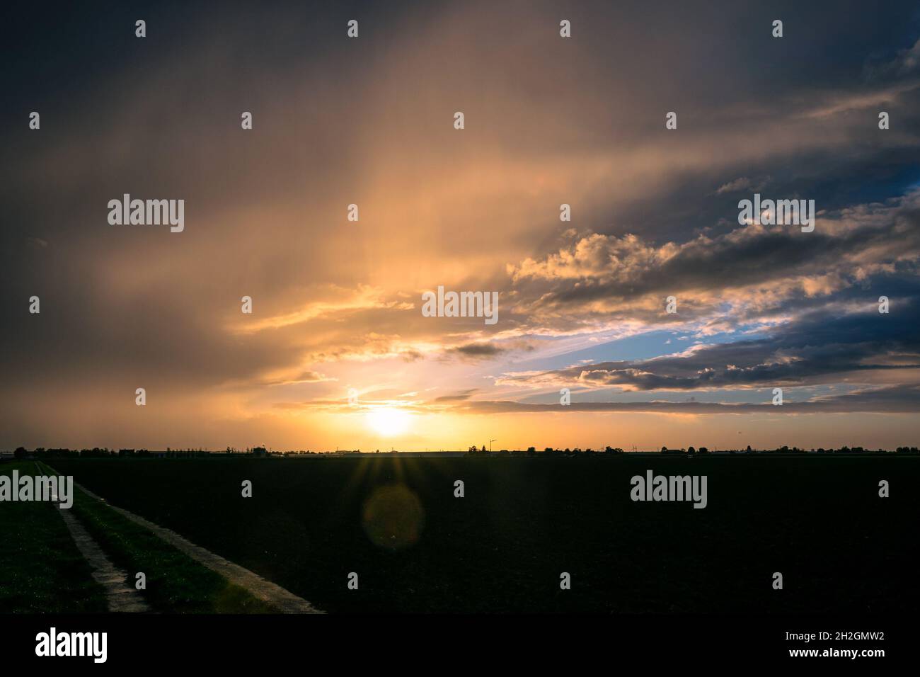Bei colori nelle nuvole dopo il passaggio di un fronte freddo. Alcune lenti svasate sono visibili nella parte inferiore dell'immagine. Foto Stock Bei colori nelle nuvole dopo il passaggio di un fronte freddo. Alcune lenti svasate sono visibili nella parte inferiore dell'immagine. Foto Stock