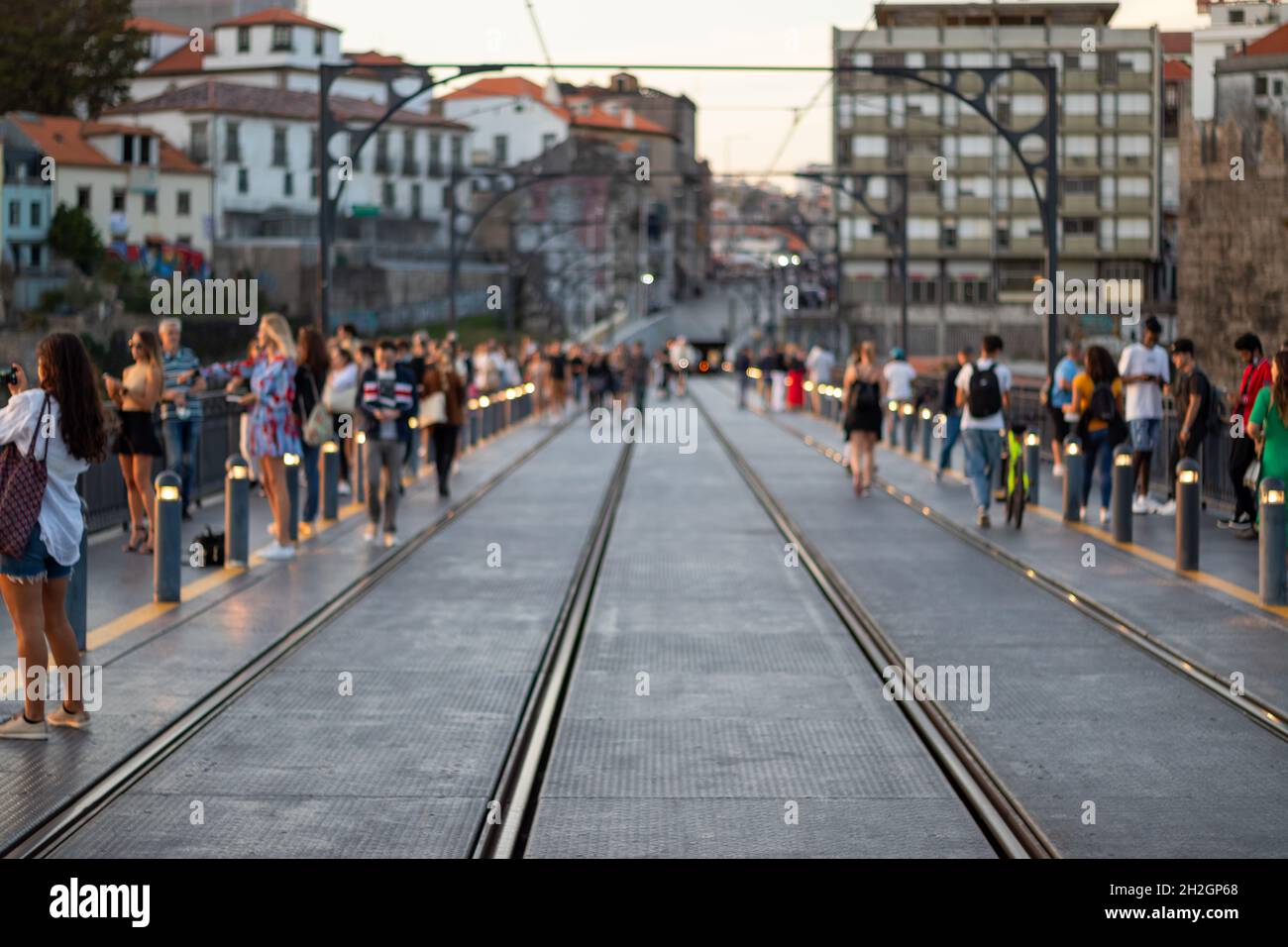 Astratto offuscato persone a piedi. Ponte di Porto Dom Louis pieno di turisti irriconoscibili che scattano foto al tramonto Foto Stock