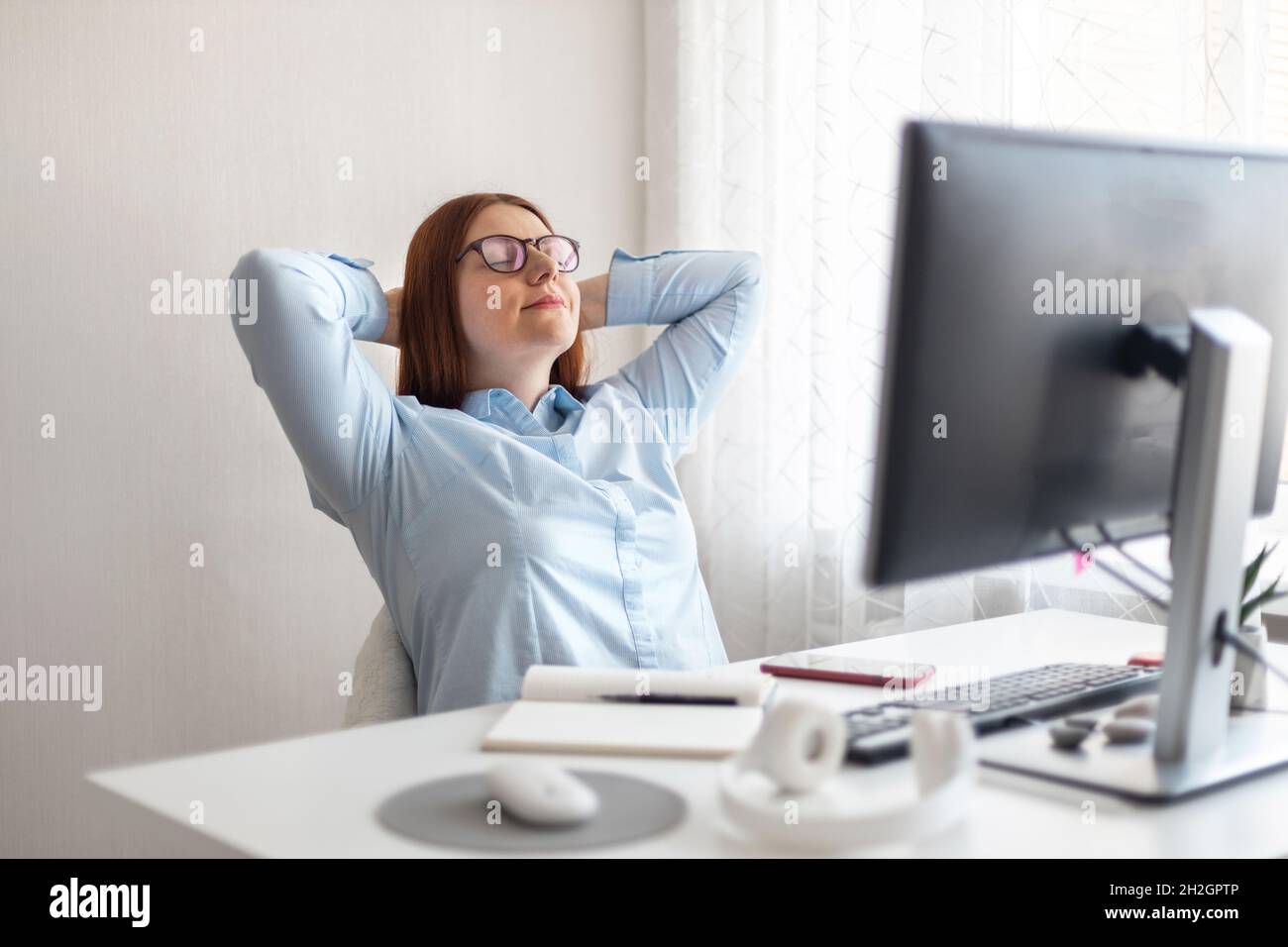 Felice studente rilassarsi dopo un lungo periodo di apprendimento a distanza da PC in ufficio a casa. Foto Stock