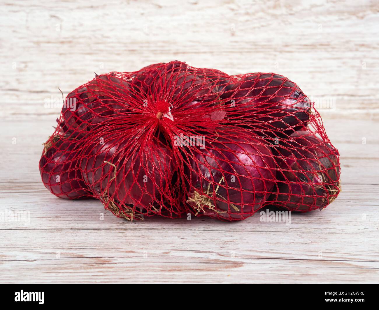 Una piccola borsa con cipolle rosse Foto Stock