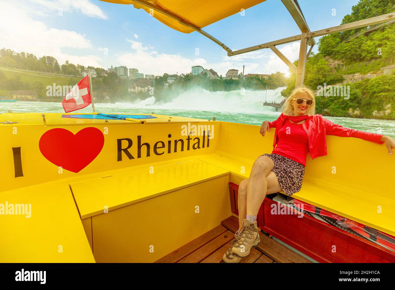 Donna in barca sulla cascata svizzera Rheinfall in Svizzera al tramonto. 490 piedi di larghezza e 75 piedi di altezza. Schaffhausen e Zurigo Cantoni di Foto Stock